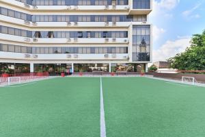 an empty tennis court in front of a building at Hotel Nacional Inn Campinas Trevo in Campinas