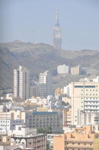 eine Stadt mit einem Uhrturm im Hintergrund in der Unterkunft Luxurious Hilltop Apartment 9 minutes from Haram in Mekka