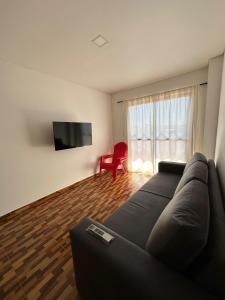 プエルト・リコにあるLas Calasのリビングルーム(ソファ、赤い椅子付)