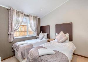 2 camas en una habitación con ventana en Scottish retreat en Banchory