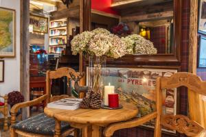 a table with a candle and a vase of flowers at Hotel Aran La Abuela in Vielha