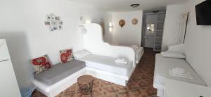 ein weißes Wohnzimmer mit 2 weißen Sofas und einem Stuhl in der Unterkunft Anemos Sea View in Batsi