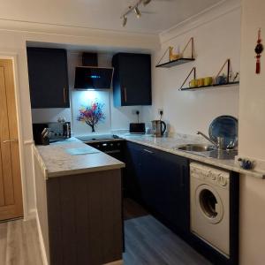 een keuken met een wastafel en een wasmachine bij Darcey's Apartment in Bowness-on-Windermere