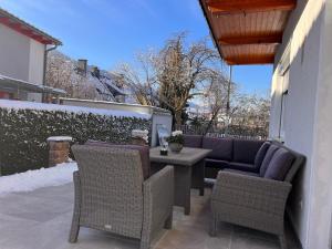 eine Terrasse mit Stühlen, einem Tisch und einem Sofa in der Unterkunft Ferienwohnung ImZaro: Erdgeschoss, 2 Schlafzimmer plus Schlafsofa, eigener Eingang, große Terrasse mit Garten! in Spittal an der Drau