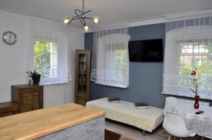 Habitación con cama, mesa y ventanas. en Gościniec Zapiecek en Stronie Śląskie