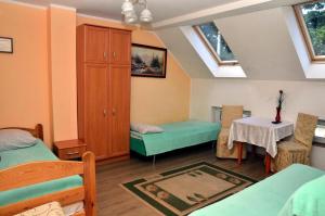 a room with two beds and a table at Gościniec Zapiecek in Stronie Śląskie