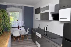 a kitchen with black and white cabinets and a table at Gościniec Zapiecek in Stronie Śląskie