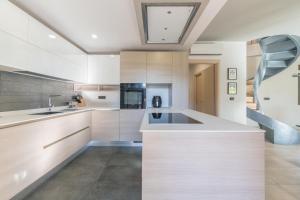 a kitchen with white cabinets and a sink at Charming Apartment La Pollona in Torino