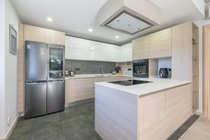 a kitchen with white cabinets and a stainless steel refrigerator at Charming Apartment La Pollona in Torino