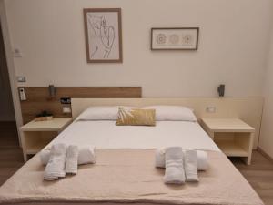 a bedroom with a large white bed with two pillows at Simona Rooms in Portocannone