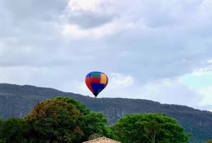 um balão de ar quente no céu sobre as árvores em Pousada Vovô Juca Tiradentes em Tiradentes