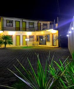 uma casa com persianas amarelas e verdes à noite em Pousada Vovô Juca Tiradentes em Tiradentes