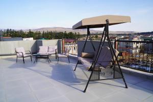 un portico con sedie e ombrellone sul tetto di Tbilisi Sea Hotel a Tbilisi City