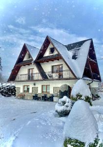 dom pokryty śniegiem w obiekcie Dom Wypoczynkowy Julia w mieście Białka Tatrzanska