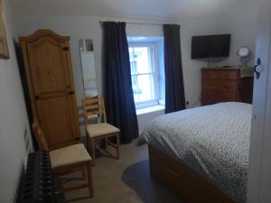 a bedroom with a bed and a dresser and a window at Lyndale House in Bradwell
