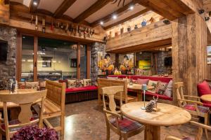 a restaurant with wooden tables and a red couch at Hotel Aran La Abuela in Vielha