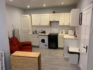 a kitchen with white cabinets and a washing machine at Parnell Place Apartments in Dublin