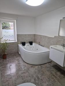 a white bath tub in a bathroom with a sink and a toilet at Ferienhaus in Burgenlandkreis (Osterfeld) in Osterfeld