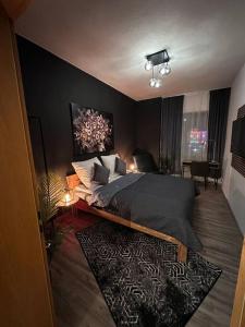 ein Schlafzimmer mit einem Bett mit einer schwarzen Wand in der Unterkunft 3 Zimmer Apartment mitten in Altstadt - Koblenz in Koblenz