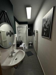 uma casa de banho com um lavatório e um espelho em 3 Zimmer Apartment mitten in Altstadt - Koblenz em Koblenz