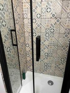 una doccia con porta in vetro in bagno di Le petit Rochambeau a Vendôme