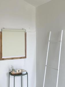 a white room with a shelf and a mirror at Monko Mini room in Pai