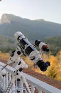 a telescope on top of a building with a mountain view at Olympus View Rooms Sauna & Spa in Litochoro