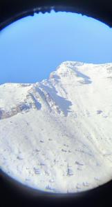 a view of a snow covered mountain from an airplane window at Olympus View Rooms Sauna & Spa in Litochoro