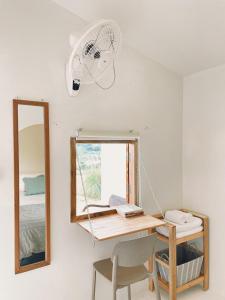 a room with a desk with a mirror and a fan at Monko Mini room in Pai