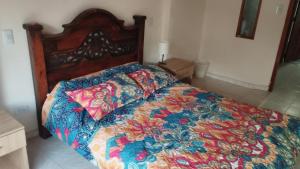 Una cama con un edredón colorido en un dormitorio en Mammamia CasaHotel, en Duitama