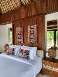 a bedroom with a large white bed with wood paneling at KANDORA Luxury villas in Maujawa +53 photos
