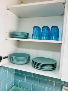 um armário com pratos azuis e pratos de vidro azul em APARTAMENTO NUEVO CÉNTRICO en PRIMERA Línea de playa con vistas al Mar, Piscina, aire acondicionado y wifi em Peníscola