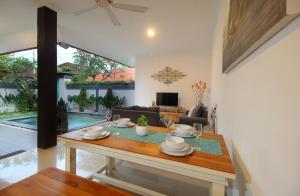 a living room with a table and a couch at Villa Lotus Flower Sanur in Sanur