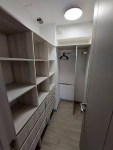 a walk in closet with shelves and a light at Apartamento Nuevo Mall y metro Plaza Egaña in Santiago