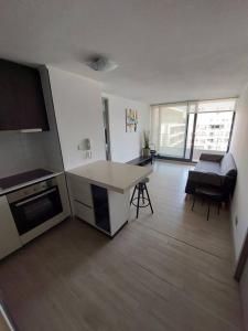 a kitchen and living room with a table and chairs at Apartamento Nuevo Mall y metro Plaza Egaña in Santiago