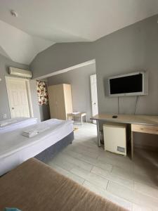 Großes Zimmer mit einem Bett und einem Flachbild-TV. in der Unterkunft EMAN TERMAL HOTEL in Ilıcalı