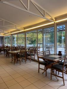 a dining room with tables and chairs and windows at EMAN TERMAL HOTEL in Ilıcalı