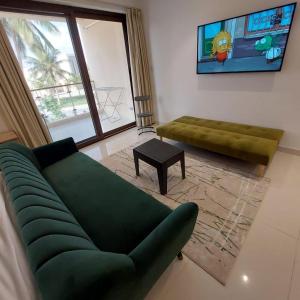 uma sala de estar com um sofá verde e uma mesa em Hawana salalah luxury studio em Wādī Khasbar