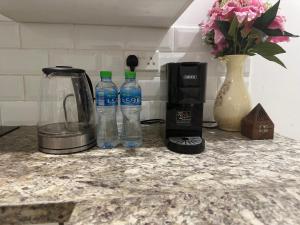 a counter with two bottles of water and a coffee maker at Hawana salalah luxury studio in Wādī Khasbar