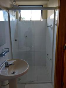 een witte badkamer met een douche en een wastafel bij Casa Santa Cruz in Passo Fundo