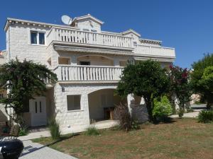 Cette grande maison blanche dispose d'un balcon. dans l'établissement Villa Skoric, à Orebić