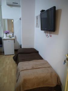 a room with a bed with a flat screen tv on the wall at Artemide Rent BedRooms in Agrigento