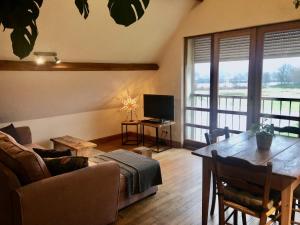 a living room with a couch and a table at Le Chêne Doux in Glandon