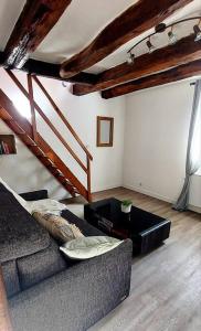 a living room with a couch and a staircase at Maisonnette in La Croix-en-Touraine