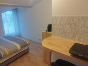 Un dormitorio pequeño con una cama y un escritorio. en Studio au coeur de la ferme, en Saint-Lumine-de-Coutais