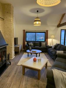 a living room with a couch and a table at Gîte de la Forge, l'Atelier in Fléré-la-Rivière
