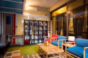 a library with two chairs and a book shelf with books at Apollonia Hotel Apartments in Varkiza