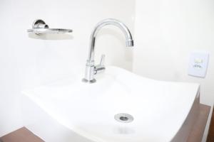 a sink with a faucet in a bathroom at Cobertura Enseada de Zimbros in Bombinhas