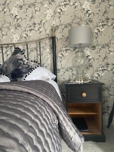 a bedroom with a bed and a lamp on a nightstand at Abbey Green Farm in Wem