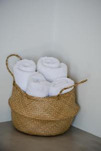 a basket filled with white towels in a wall at Rooster Guesthouse Rooms in Kipri